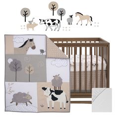 a baby crib bedding set with farm animals and trees on the wall next to it