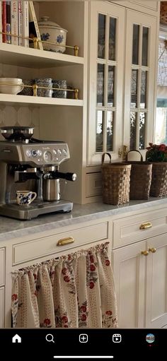 a coffee maker is on the counter in a kitchen with white cabinets and cupboards