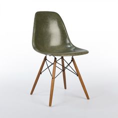 a green chair with wooden legs on a white background