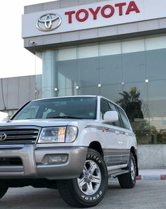 a silver suv parked in front of a toyota dealership