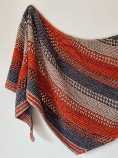 an orange and blue striped shawl hanging on a wall