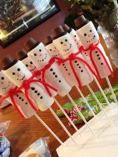 marshmallow snowmen are wrapped in red ribbon and placed on top of each other