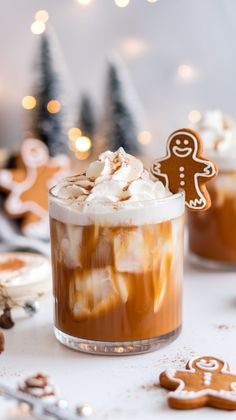 two glasses filled with hot chocolate and marshmallows on top of a table