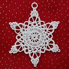 a white snowflake ornament sitting on top of a red table cloth