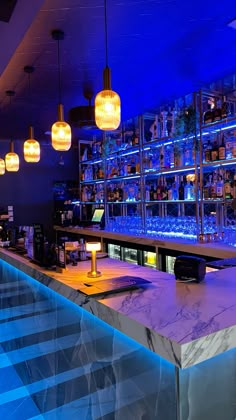 a bar with blue lights and marble counter top