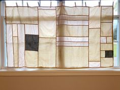 the curtains are hanging on the window sill in the room that is decorated with brown and white squares