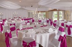 the tables are set up with white and pink linens for an elegant wedding reception