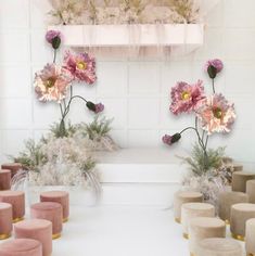 several vases with flowers in them sitting on a shelf next to candles and other decorations