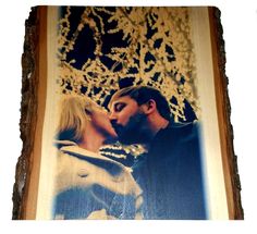 a man and woman kissing each other in front of a tree with snowflakes on it