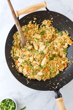 a pan filled with rice and vegetables on top of a table