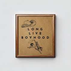 a framed poster with the words long live boyhood in black ink on brown paper