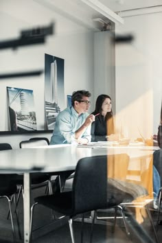 three people sitting at a table in an office