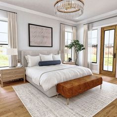 a large bed sitting in a bedroom on top of a hard wood floor next to two windows