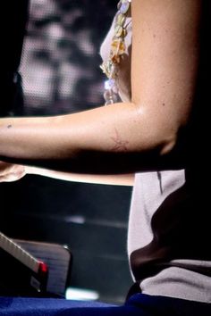 a person with a tattoo on their arm playing the piano