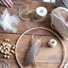 a wooden table topped with lots of crafting supplies and yarn on top of it