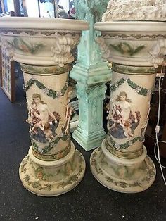 two large white vases sitting next to each other on top of a black floor