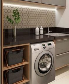 a washer and dryer sitting in a kitchen next to a counter with baskets on it