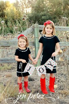 two girls in black dresses and red boots are holding hands while standing next to each other