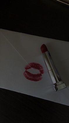 a red lipstick is laying on top of an envelope