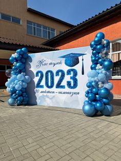 blue balloons are placed in front of a large banner for the class of 2030