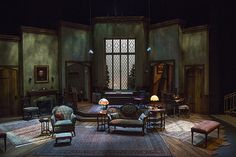 a stage set with chairs, couches and tables in the middle of an empty room