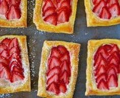 two strawberry tarts sitting on top of a pan