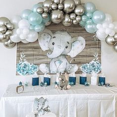 an elephant themed baby shower with balloons and flowers on the table, along with other decorations