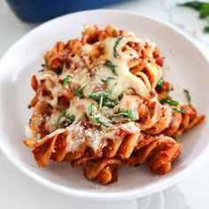 a white plate topped with pasta covered in sauce