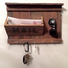 a wooden mailbox with keys and sunglasses hanging on the wall