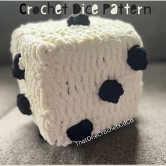 a close up of a knitted object with black dots on white yarn and text that reads crochet dice pattern