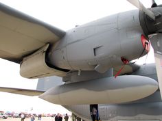 the tail end of an airplane with people standing around it