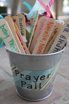 a bucket filled with wooden spoons sitting on top of a sidewalk