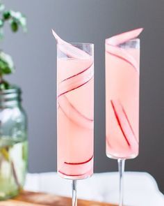 two glasses filled with pink liquid sitting on top of a table