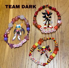 three bracelets with different designs on them and the words team dark written in large letters