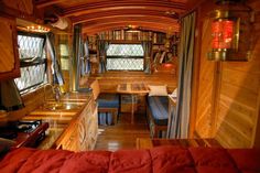 the interior of a tiny house with wood paneling and red bedspreads