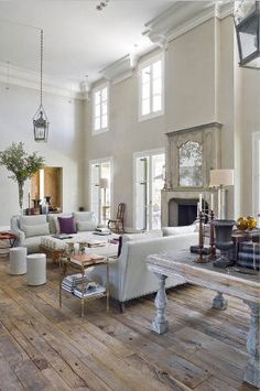 a living room filled with furniture and a fire place in the middle of an open floor plan