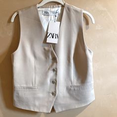 Zara Light Tan Vest / Waistcoat - Size S - A Relaxed Feel On New With Tags Sleeveless Vest/Top Is Lined And Has Buttons Up The Front. 2 (False) Front Pockets And A Back Vent. Approx. Measurements Laid Flat: Underarm To Underarm: 17.5” Length Center Back To Hem: 18.5” Exterior 62% Viscose 38% Lyocell Lining 100% Viscose Excellent Condition, Never Worn. Item Bought In Switzerland. Cover Photo Is A Stock Photo Not Item For Sale. Spring Office Vest Single Breasted, Spring Single-breasted Office Vest, Tailored Spring Vest Outerwear, Spring Button-up Vest Outerwear, Beige Button-up Vest For Work, Beige Single Breasted Vest For Spring, Spring Single Breasted Vest In Beige, Beige Single-breasted Vest For Spring, Spring Beige Single Breasted Vest