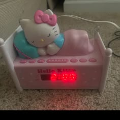 a hello kitty alarm clock on the floor