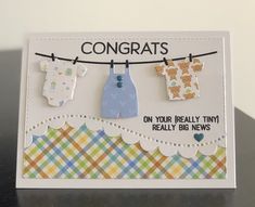 a card with clothes hanging on a line that says congrats on your really tiny really big news