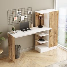 a computer desk with a laptop on top of it next to a potted plant