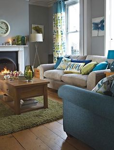 a living room filled with furniture and a fire place in front of a clock on the wall