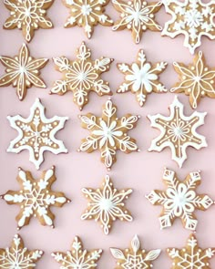 several snowflake cookies are arranged on a pink surface