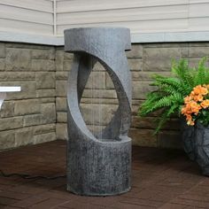 a water fountain sitting next to a potted plant