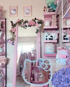 a hello kitty themed room with pink and blue decor on the walls, shelves and mirror