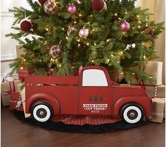 a christmas tree in a red truck with ornaments on the top and presents under it