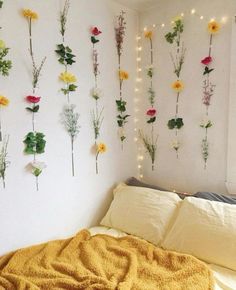 a bed room with a neatly made bed and flowers on the wall