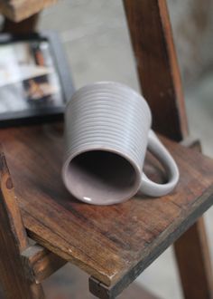 a white cup sitting on top of a wooden table