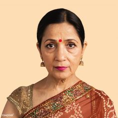 an older woman with dark hair wearing a red sari