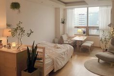 a bed room with a neatly made bed next to a desk and chair in front of a window