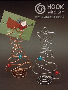 two wire christmas tree ornaments with a card attached to one ornament that has an angel on it